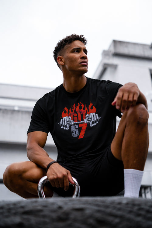 موديل يرتدي تيشيرت GYM 67 الأسود جالس خارج النادي